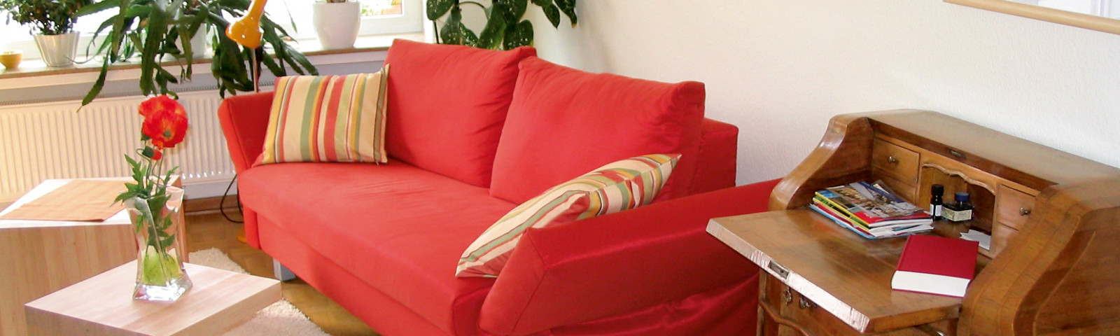 Wohnzimmer mit Couch, Sekräter und Tisch